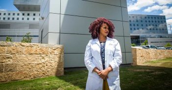 Carli Mendoza in front of Parkland Hospital, part of the UT Southwestern system where she is completing her residency