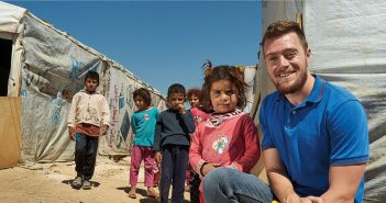 Catholic Relief Services worker and Fordham graduate Sean Kenney poses with Syrian refugee children living in Lebanon's Bekaa Valley