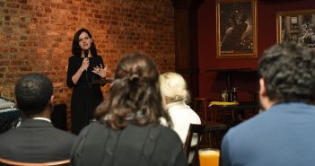 Fordham theology professor Brenna Moore delivers a "Faith on Tap" talk to a group of Fordham alumni in the backroom of a Midtown Manhattan bar