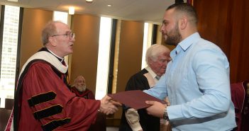 Father McShane congratulates an IDHA graduate.