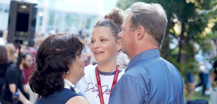 A girl embraces her parents.