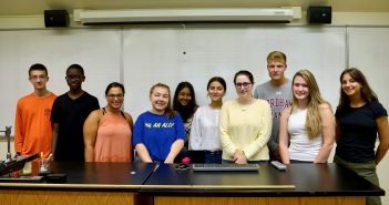 Ten students pose for a group picture in a lab.