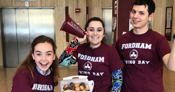 Three students wearing maroon shirts that say "Fordham Giving Day"