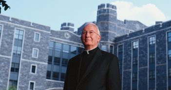 Father O'Hare in front of O'Hare Hall at Rose Hill