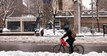 Bicycle going by snowy entrance to Fordham's Lincoln Center campus