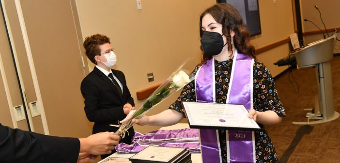 Student receiving white rose at LGBTQ Lavender Graduation