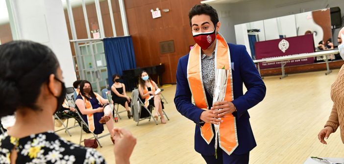 Male graduate with orange stole at Latinx graduation
