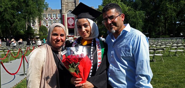 Woman with her parents posing for a picture in fromt of Keating Hall