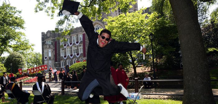A graduate leaps into the air on Edwards Parade