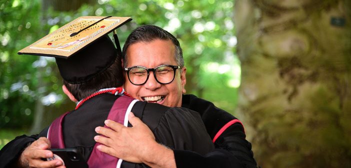 Tito Cruz gives a student a hug