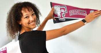 woman student posting Fordham bannner on wall