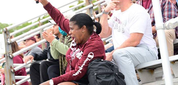 A mom cheers on her son playing football