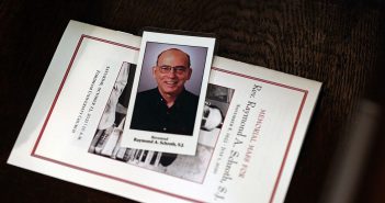 A prayer card and memorial Mass program featuring a photo of the late Fordham professor and dean Raymond A. Schroth, S.J.