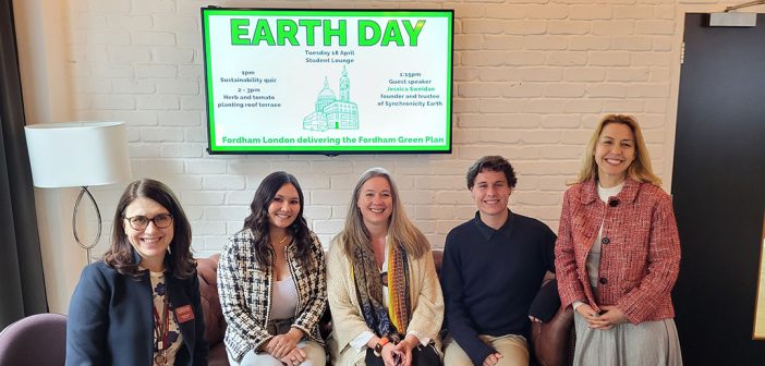 4 women and 1 man posing in front of Earth Day sign on TV