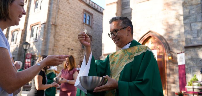 A man gives out crackers at Mass.