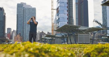 Dustin Partridge looking through binoculars on the roof of the Javits Center
