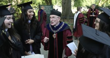 Father McShane speaks with graduating seniors at a Fordham commencement.