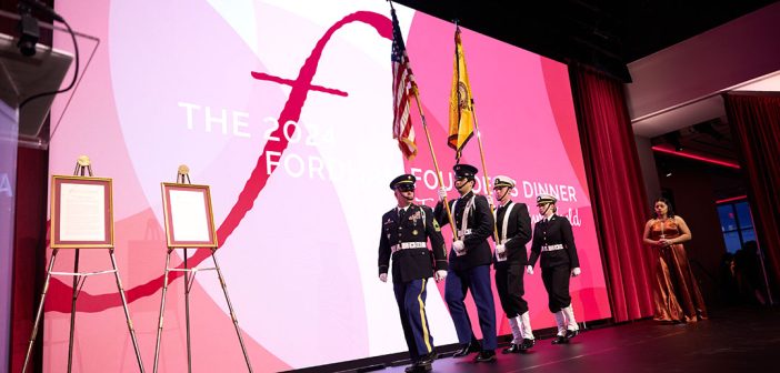 A military color guard walks on stage