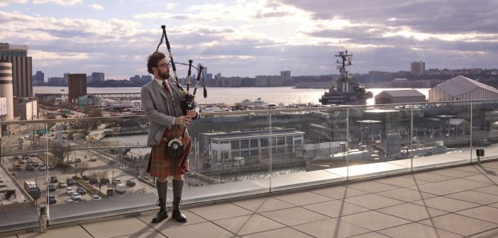 a man plays the bagpipes on a porch