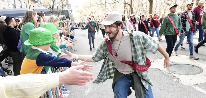 A parade participant gives a high-five to a member of the crowd.